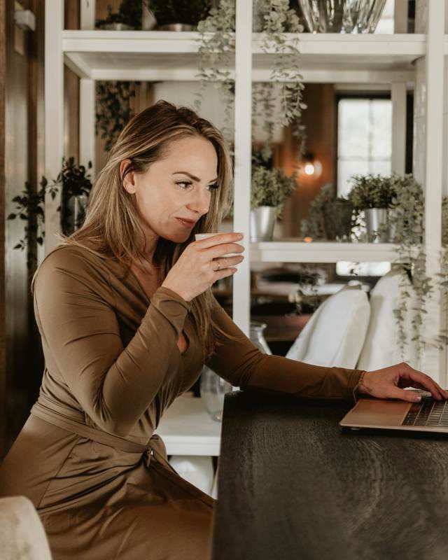 Joyce achter haar laptop met een kop koffie